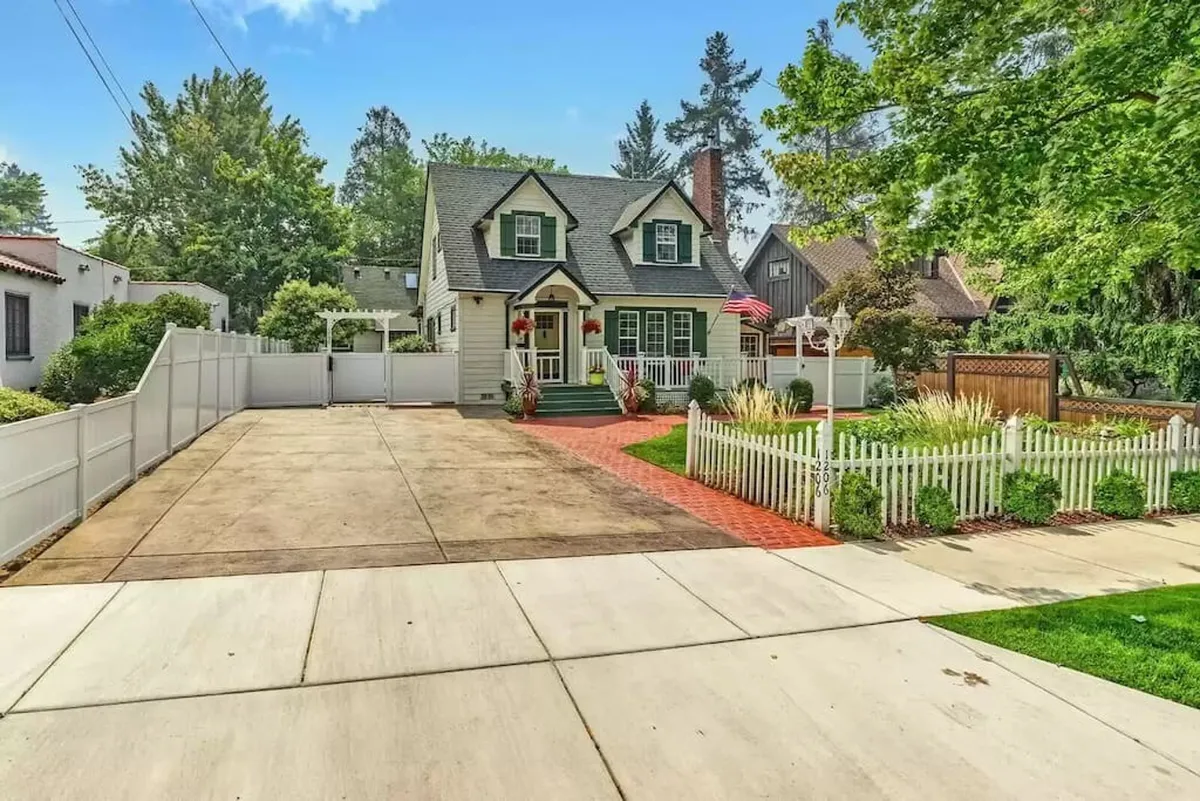 An inviting home façade with a manicured garden and a brick walkway leading up to a welcoming porch. The setting is bright and cheerful, ideal for outdoor activities like morning coffee, sunset watching, or festive family celebrations.